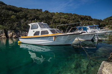 Obraz premium A small amount of old boats is moored in a picturesque bay or small marina on the island of Krk, Croatia on a sunny day.