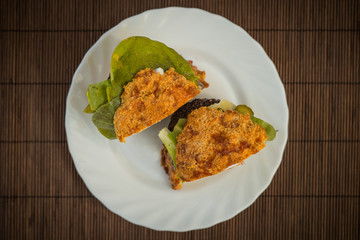 LCHF Low carbohydrate high fat burger or hamburger meal. LCHF burger with non carbohydrate bread made of sesame, eggs, chees, almonds. Concept picture of a LCHF burger in front of television screen.
