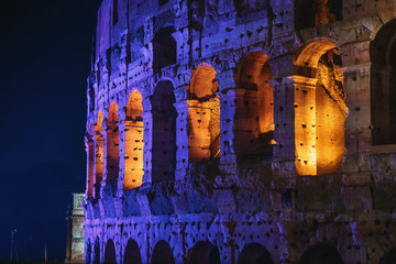Colosseum or Coliseum wall with night illumination. Huge Roman amphitheatre in Rome, Italy.