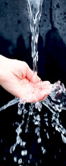 Selective focus. Female hand under a stream of clear water. Splashing water. Cold water source....
