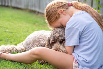 young girl cuddling pet dog