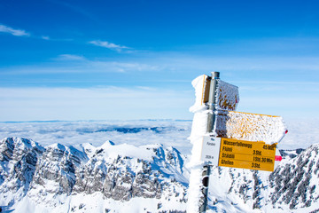 snow-covered signpost at the top of the snowy mountain. winter sport achievement concept