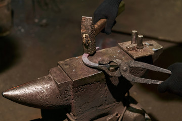 blacksmith forges a horseshoe, close-up