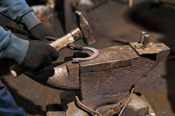 blacksmith forges a horseshoe, close-up