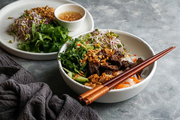 bowl of traditional Vietnamese noodle salad - Bun Bo Nam Bo, with beef, rice noodles, fresh herbs,...