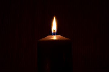 Close up of burning candle in the dark