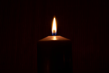 Close up of burning candle in the dark