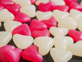 Red and white jelly hearts on dark background. Abstract love and Saint Valentine background.