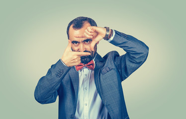 Mature businessman making frame with fingers.