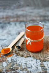 Warm water with turmeric in a glass. Turmeric and black pepper. Selective focus. Macro. Golden water.