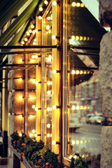 Obraz premium The facade of the restaurant building is decorated with lights. vertical.