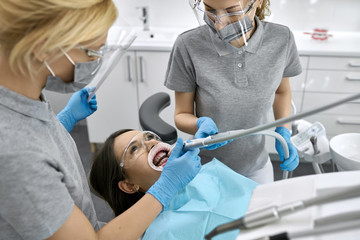 Pretty woman's teeth cleaning in dental clinic