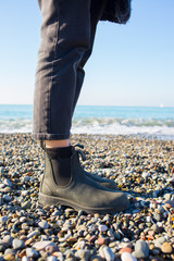 Chelsea boots classic black leather rubber sole. Focus on legs of hipster woman wearing denim black...