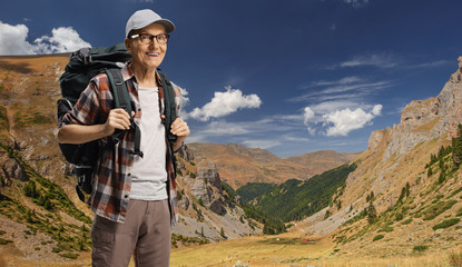 Fototapeta na wymiar Elderly man hiker with a backpack posing on Shara mountain
