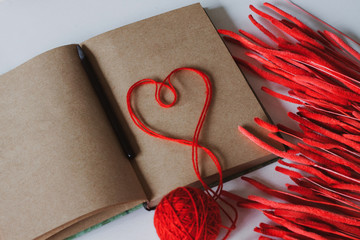 Notebook with craft sheets. a heart of red threads and red gry grass phleum. There is space for copies.