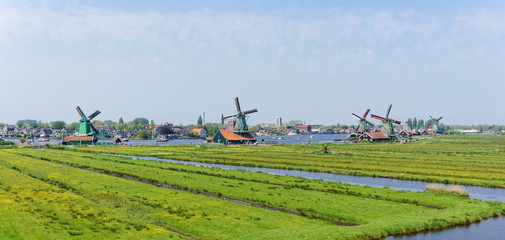 Fototapeta na wymiar Panoramic view of Dutch windmills at Zaanse Schans in Netherlands