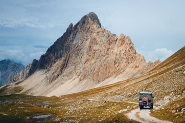 Off road caravain driving on a narrow path near the Rocca La Meja, famous mountain peak in che Alps...