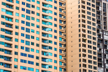 Fototapeta premium Close up of a yellow block of flats facade packed of windows