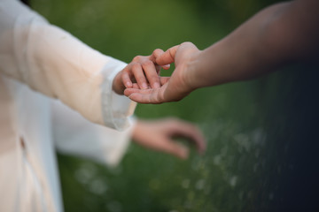 Hand in hand with green and bokeh background,select focus.