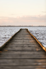 Fototapeta premium Holzsteg im Meer im Sonnenuntergang