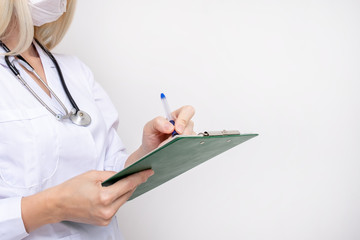 Woman female doctor writing on clipboard a diagnosis and prescription after examination of a patient, copy space