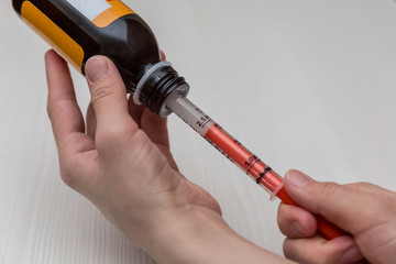 Filling an antipyretic medication into a syringe.