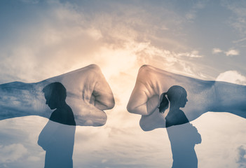 Couple with back turned away from each other with fist clashing in the background. . People...