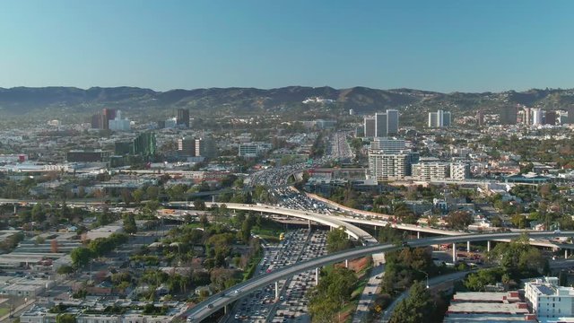 Aerial view of freeway and interstate road traffic at I-405 and I-10 intersection in urban West Los Angeles with cars below on a sunny day.