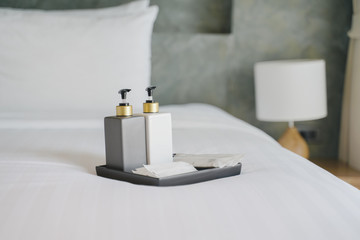 set of bathroom accessories on white bed in hotel