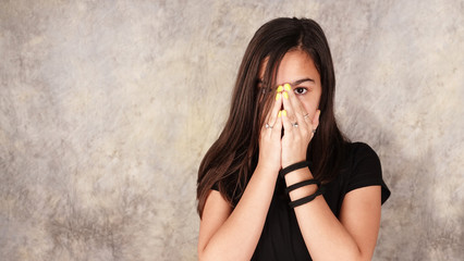 Girl is touching her face with hands and looking through