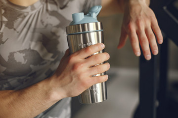 Sports man in the gym. A man performs exercises. Guy in a gray t-shirt