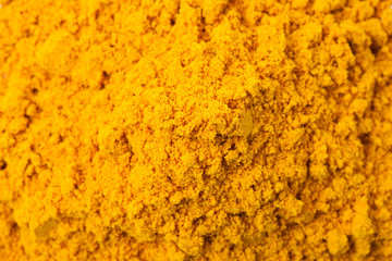 Turmeric powder background. Empty space for text or inscription. Top view. Selective focus.