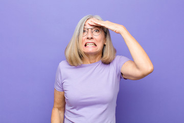 senior or middle age pretty woman panicking over a forgotten deadline, feeling stressed, having to...