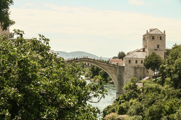 Fototapeta na wymiar Old Bridge of Mostar during a sunny afternoon, with the old city visible in the background. This bridge is the symbol of the war torn main city of Herzegovina, in Bosnia