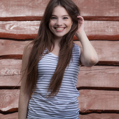 Portrait of beautiful young girl on wooden background.