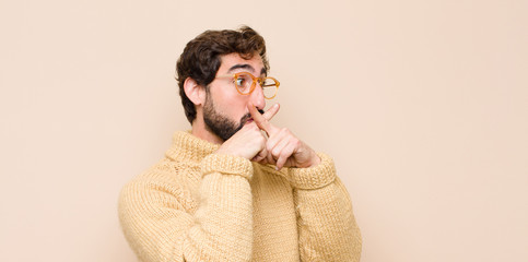 young cool man looking serious and displeased with both fingers crossed up front in rejection,...