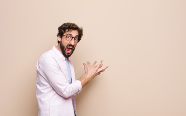 young bearded man expressing a concept against flat wall