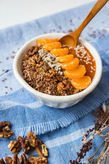Brown flax seeds healthy dietary breakfast with fruits, sesame, persimmon puree. Losing weight vegan concept.