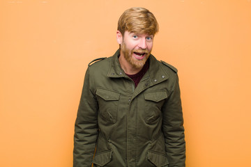 young blonde man with a big, friendly, carefree smile, looking positive, relaxed and happy,...