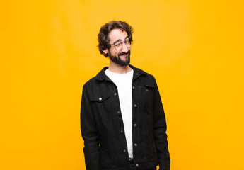young crazy handsome man looking happy and friendly, smiling and winking an eye at you with a...