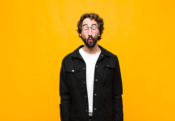 young crazy handsome man pressing lips together with a cute, fun, happy, lovely expression, sending...