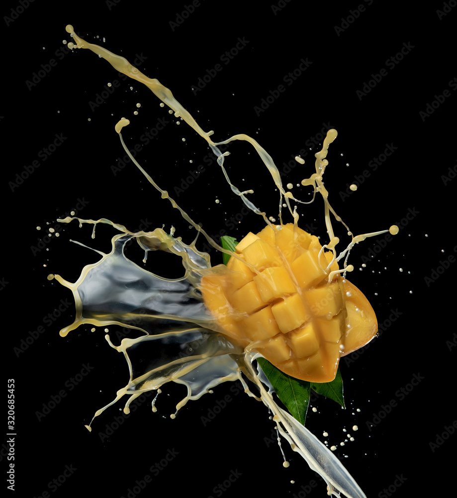 Wall mural mango slice and mango juice splash wave isolated on a black background