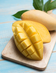 Mango slices on a blue wooden background