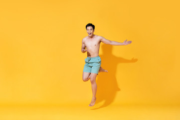 Fototapeta na wymiar Energetic smiling shirtless handsome Asian man jumping