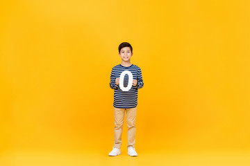 Little boy showing number zero on yellow background