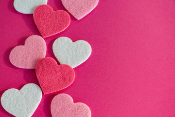 Felt fabric hearts on hot pink background, love, romance, Valentines Day symbol