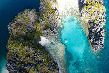 View from above, aerial view of the Big Lagoon and the Small Lagoon, two beautiful bays of crystal clear water surrounded by rocky cliffs. Miniloc Island, Bacuit Bay, El Nido, Palawan, Philippines.