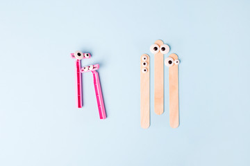 Tools for depilation on blue background - pink razor and wooden stick, top view, flat lay. Funny...