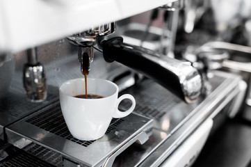 black coffee in white cup on coffee maker