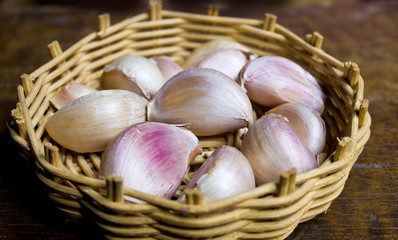Obraz na płótnie Canvas Garlic in a basket with wooden floors